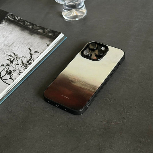 A phone case with a yellow and brown gradient design, displayed on a flat surface next to an open book.