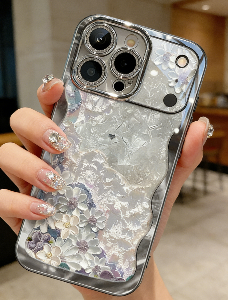 Phone case with floral design and glittery accents held by a person.