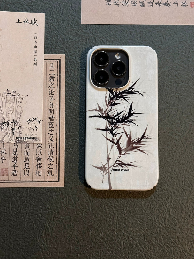 A bamboo hard protective phone case with a natural finish, displayed next to some documents and a phone, showcasing its design and fit.